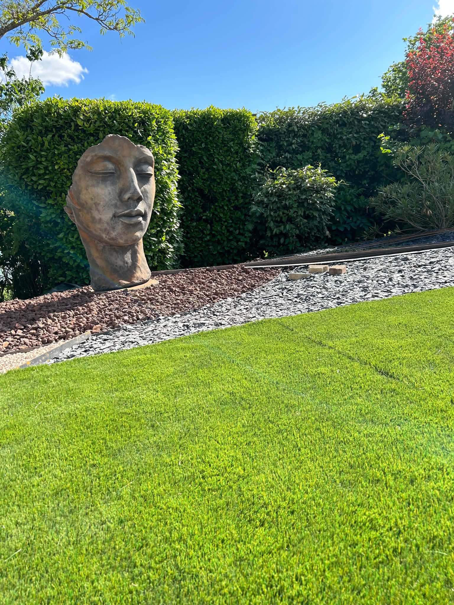 Jardin paysager avec pelouse et sculpture